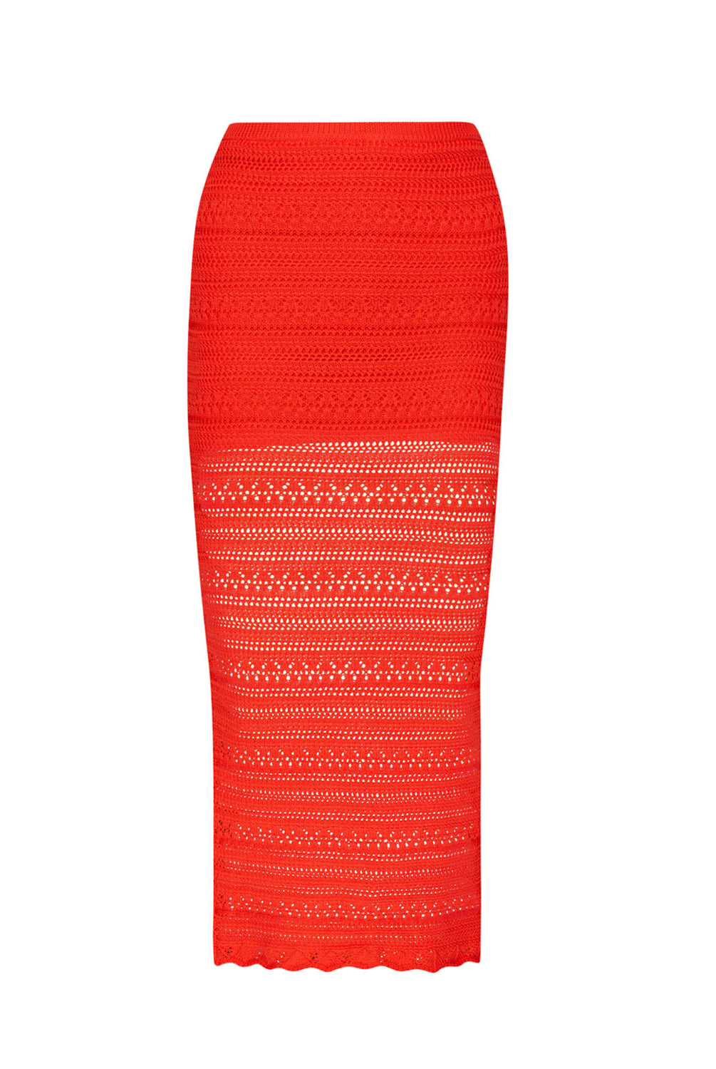 A long red crochet skirt against a white wall.