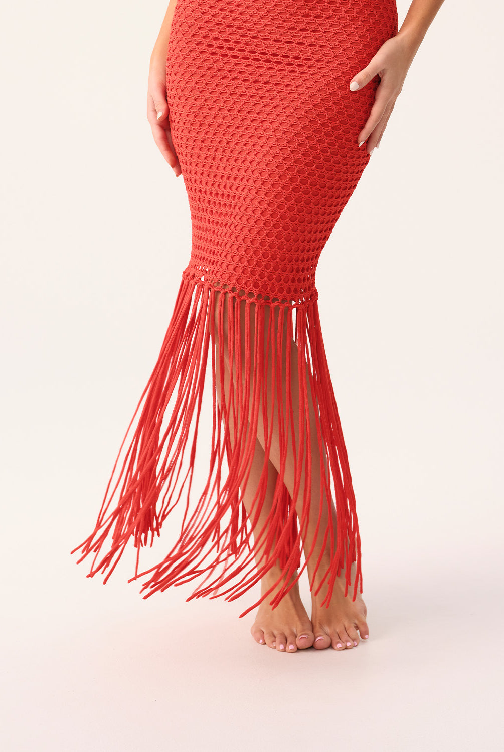 Woman wearing a red fringe dress on a white background