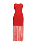 A red mesh strapless dress with fringe against a white wall.