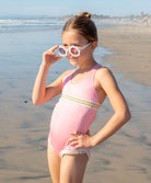 Kids Pink Sands Mabel Rainbow Embroidered One Piece – soft pink swimsuit with gold embroidery inspired by Solange Ferrarini’s colorful designs.