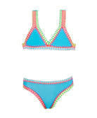 A turquoise kids bikini with colorful embroidery against a white wall.
