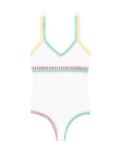 A white one piece swimsuit with colorful trim against a white wall.