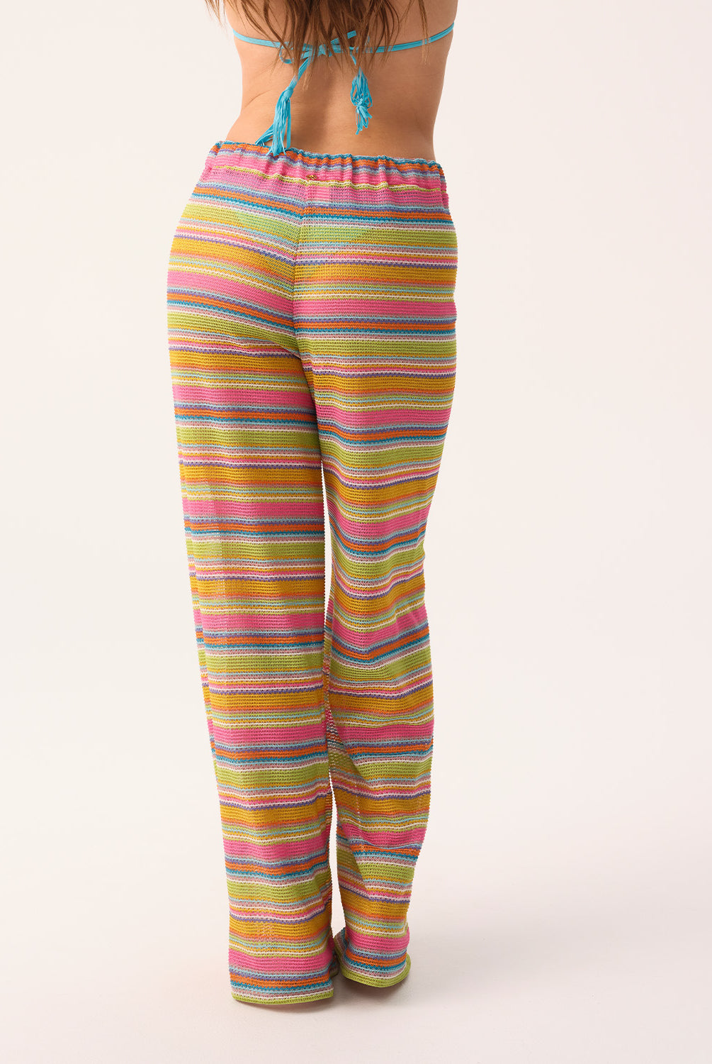 Woman wearing colorful striped pants on a white background