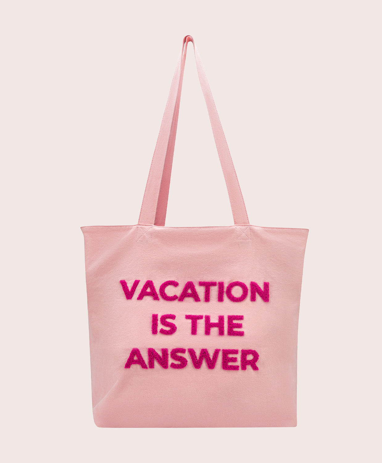 Pink tote bag with 'Vacation is the Answer' text on a light pink background
