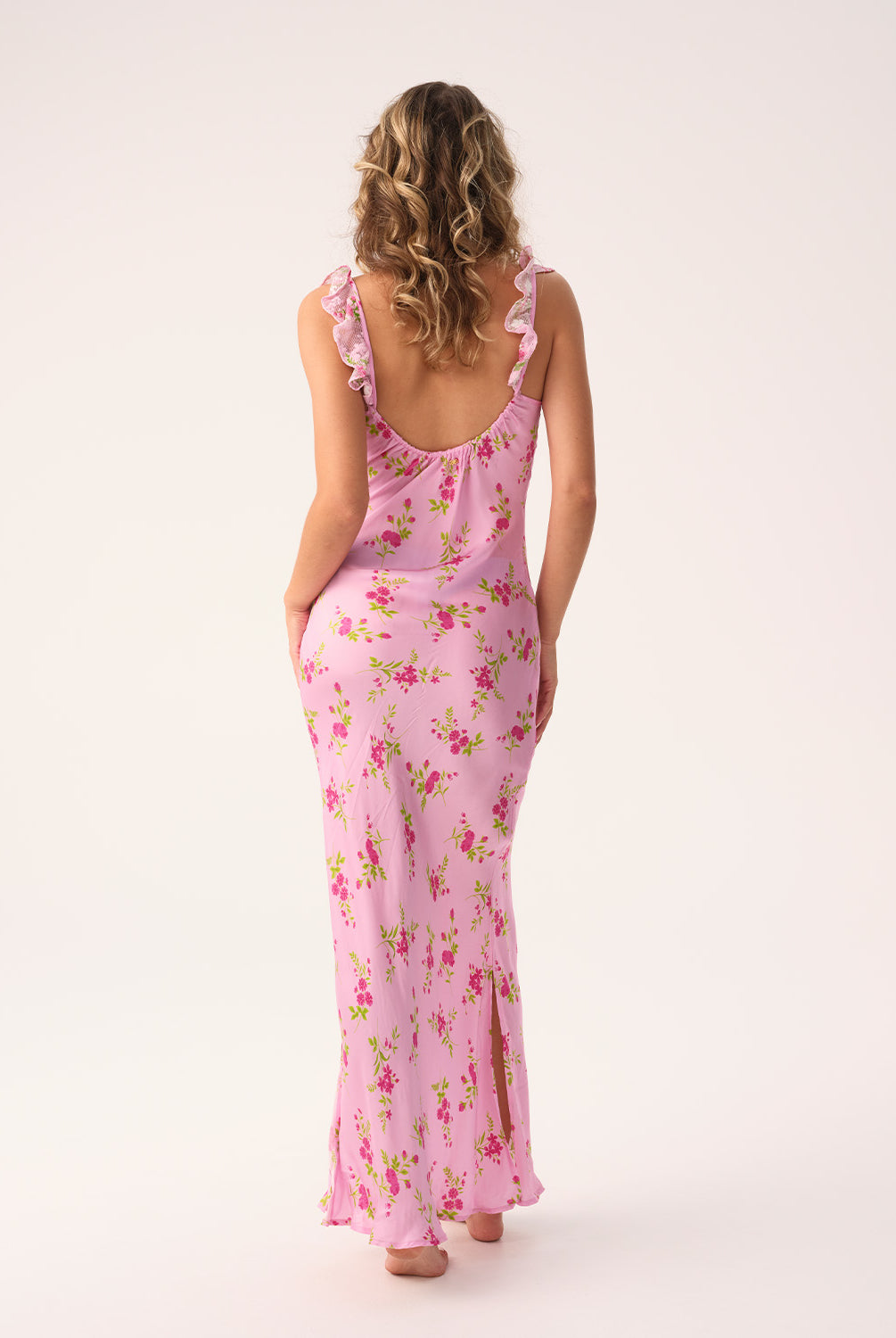 Woman wearing a pink floral long dress on a white background