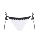 A black and white triangle bikini bottom with stud details. Featured against a white wall background.