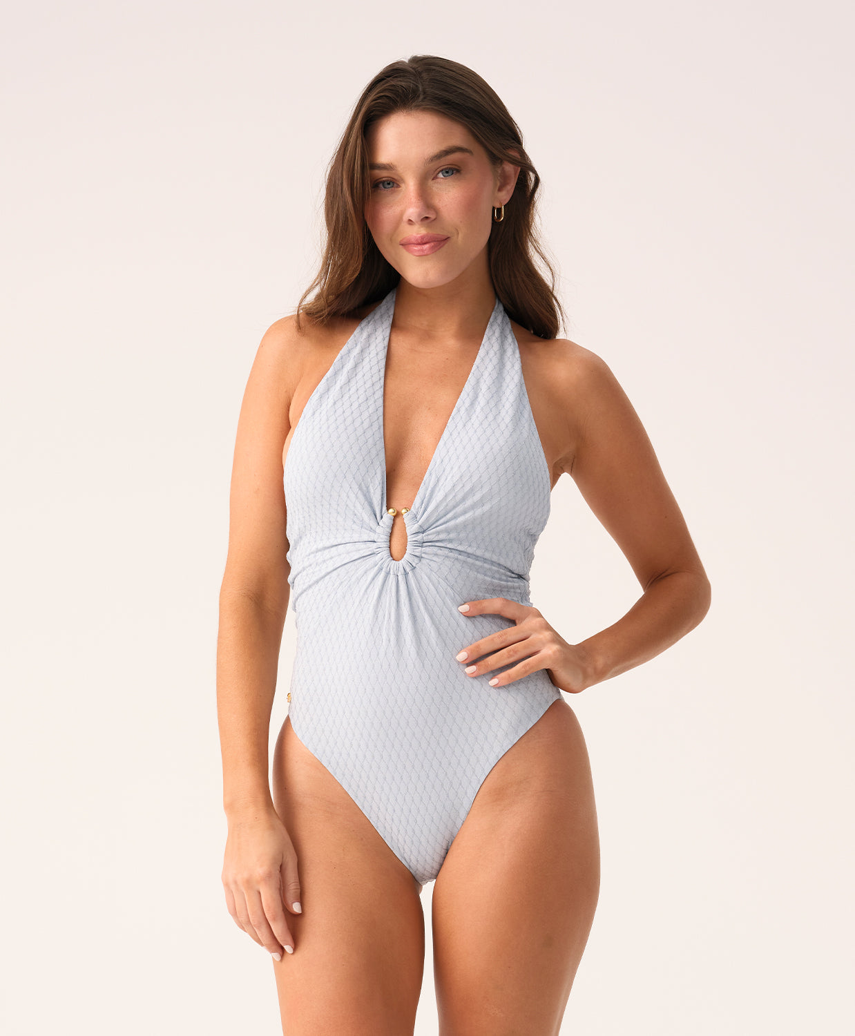 Woman wearing a light blue halter neck swimsuit on a white background