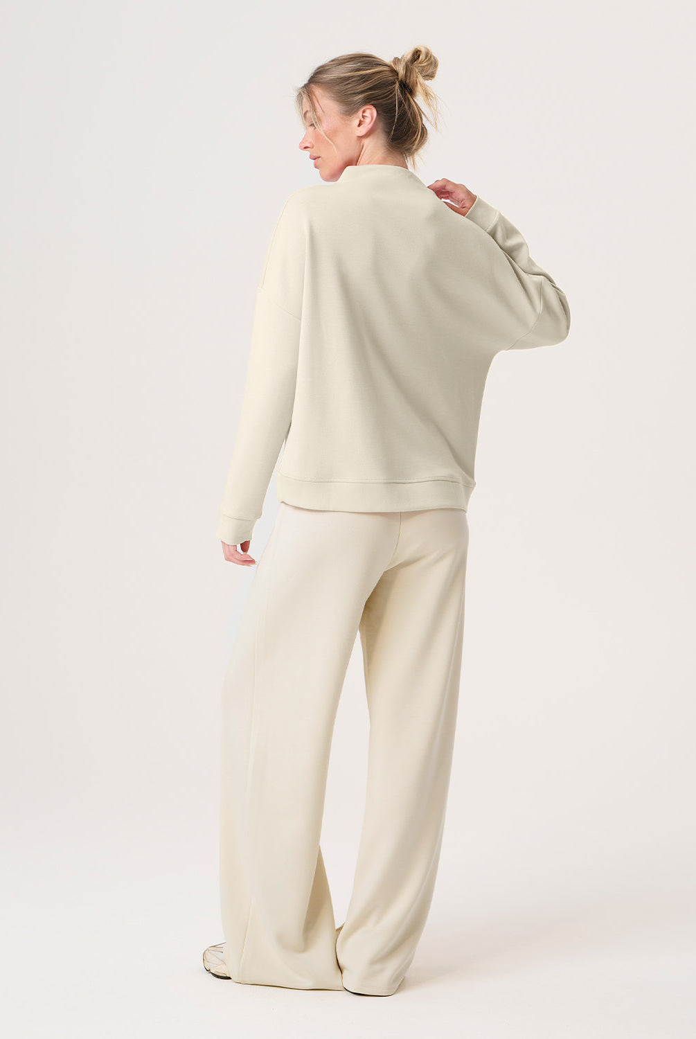 Woman wearing a beige outfit on a white background