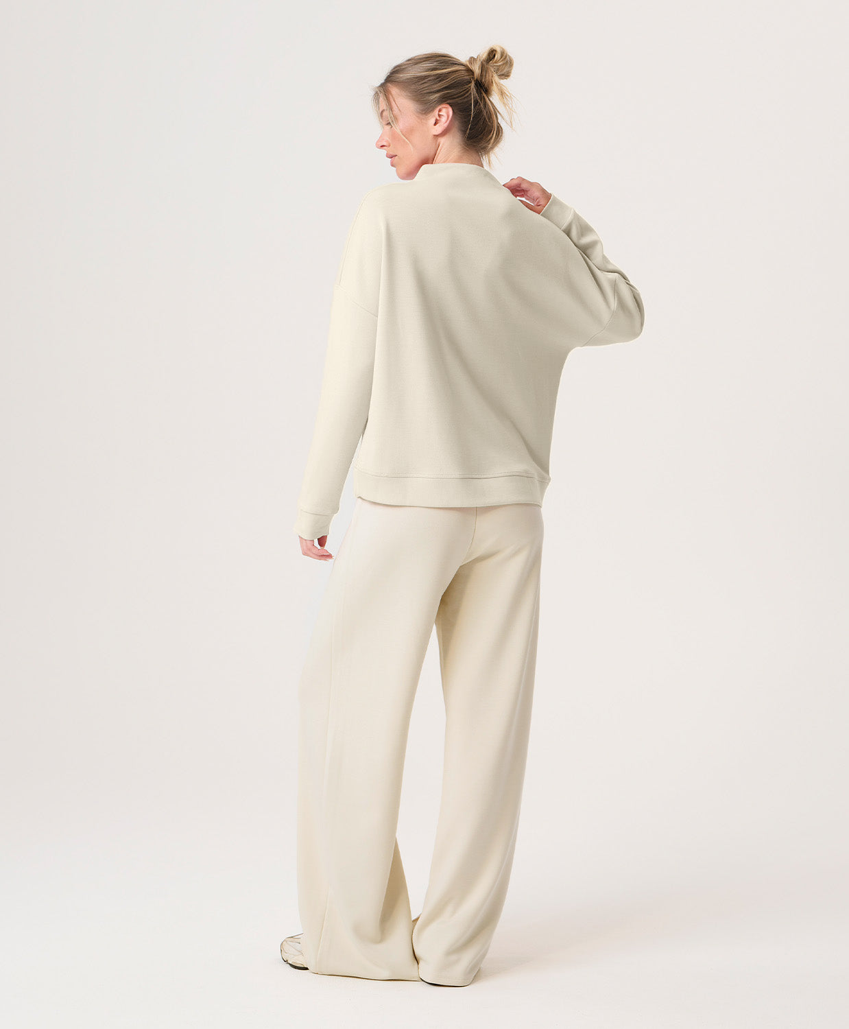 Woman wearing a beige outfit on a white background