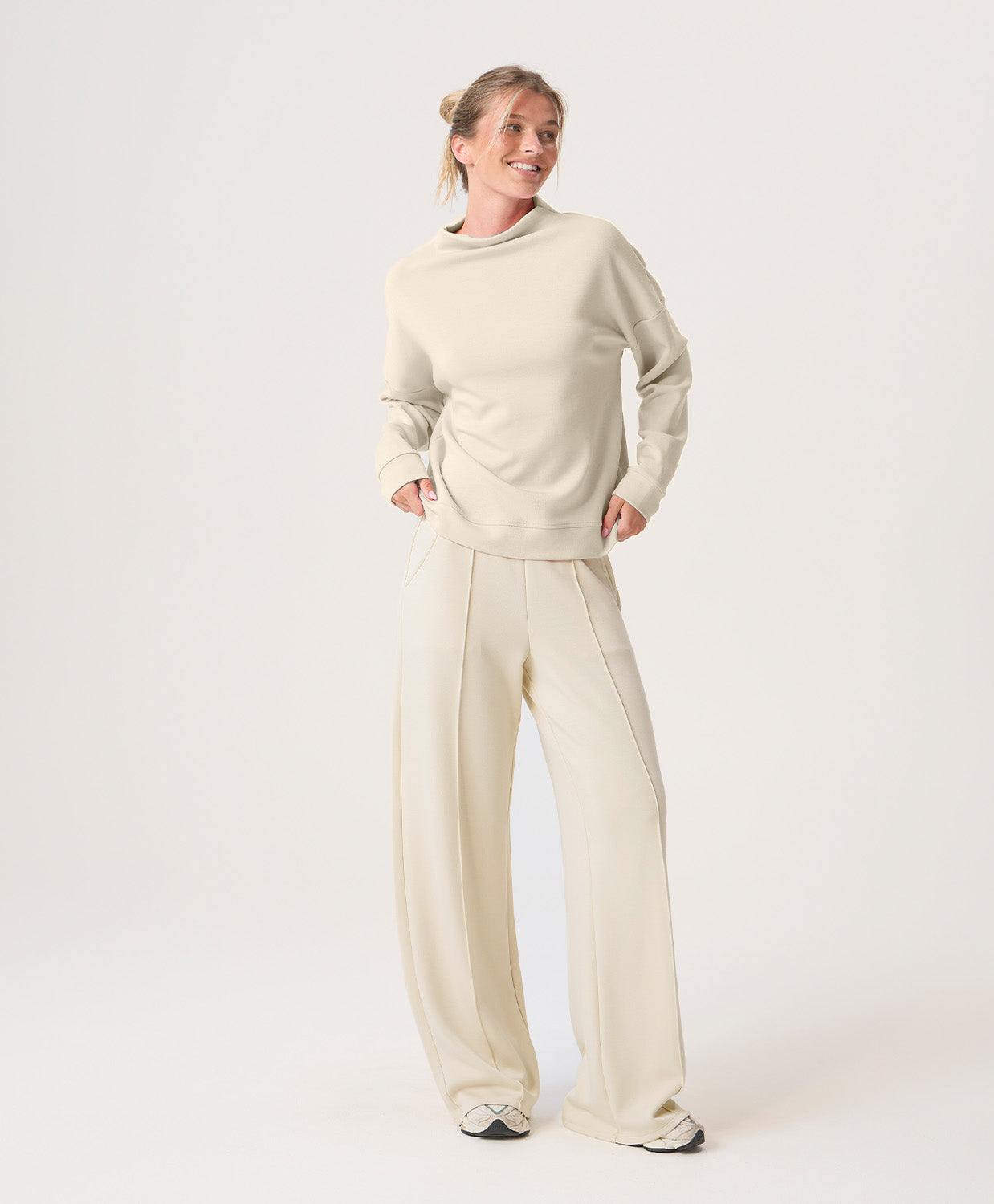 Woman wearing a beige set on a white background