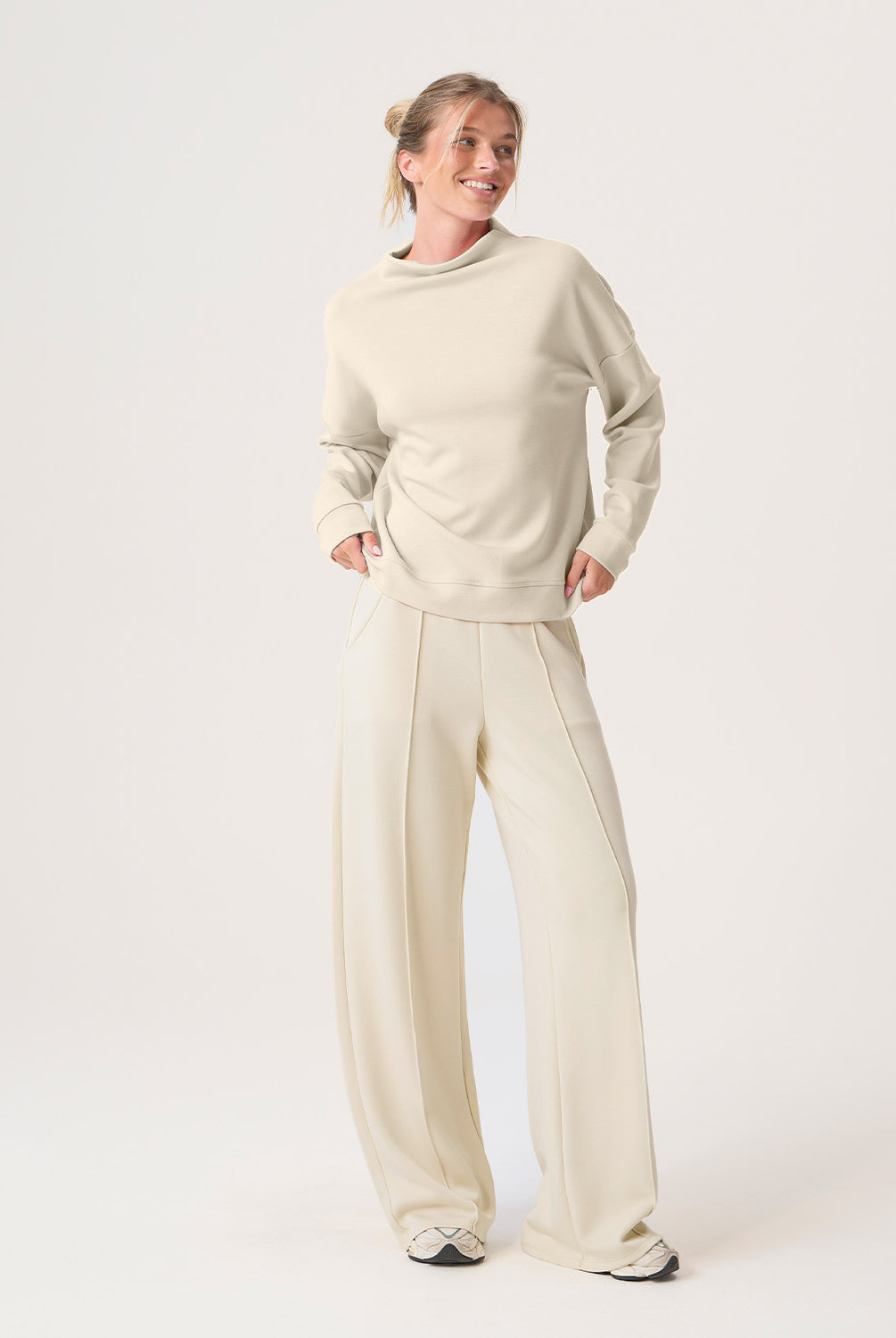 Woman wearing a beige set on a white background