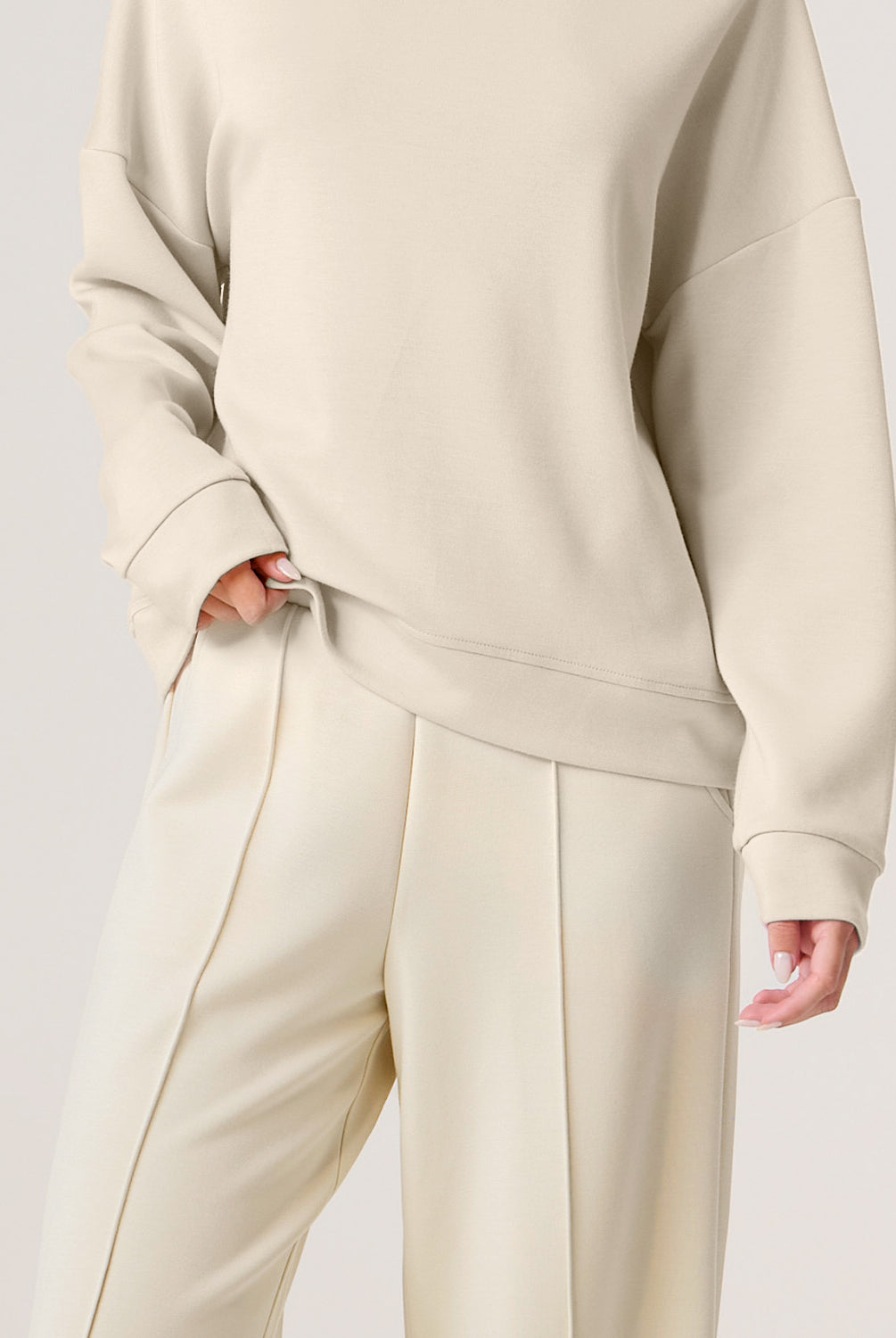 Woman wearing a beige set on a white background