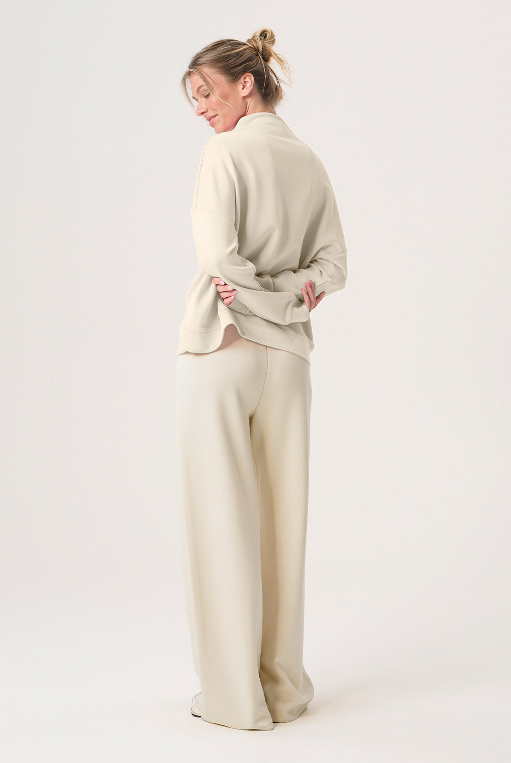 Woman wearing a beige outfit on a white background