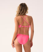 Woman wearing a pink bikini set on a white background