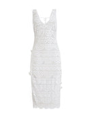 A white lace cover up dress against a white wall.