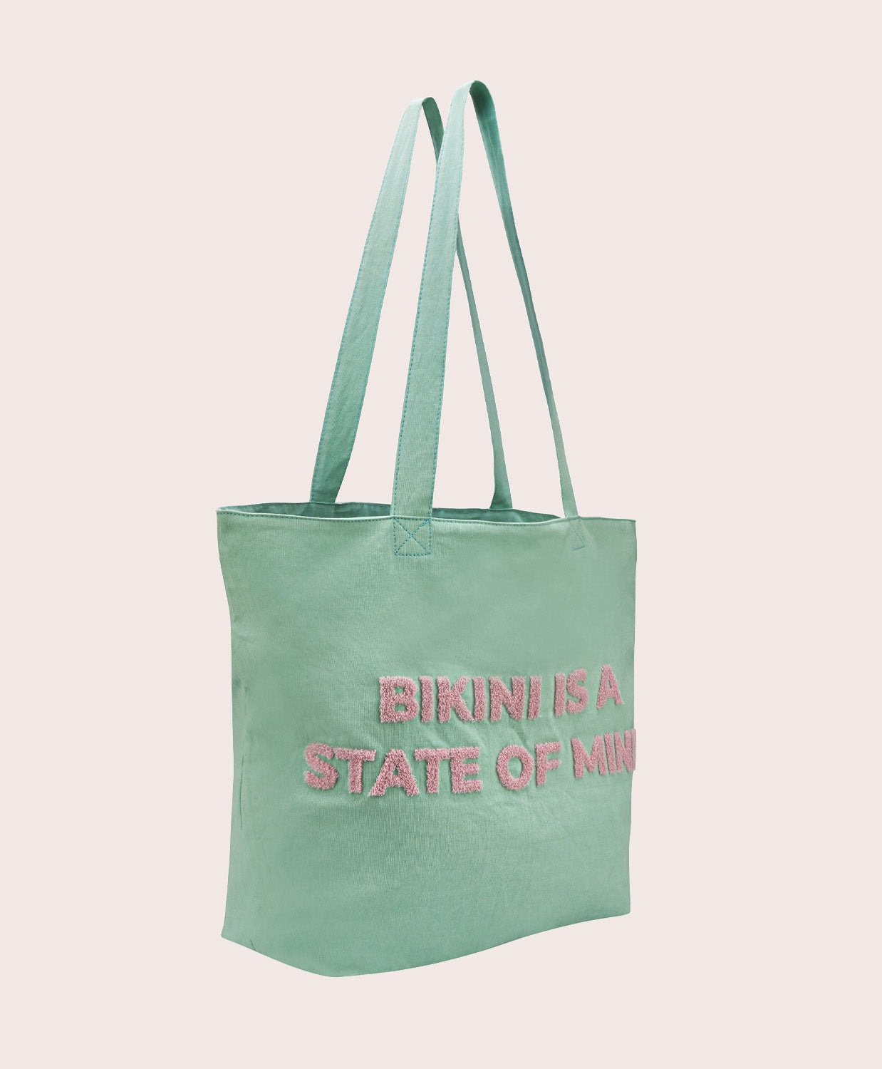 Light blue tote bag with pink text on a pink background