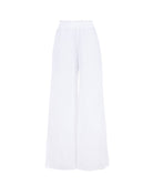 Long white linen pants against a white wall.