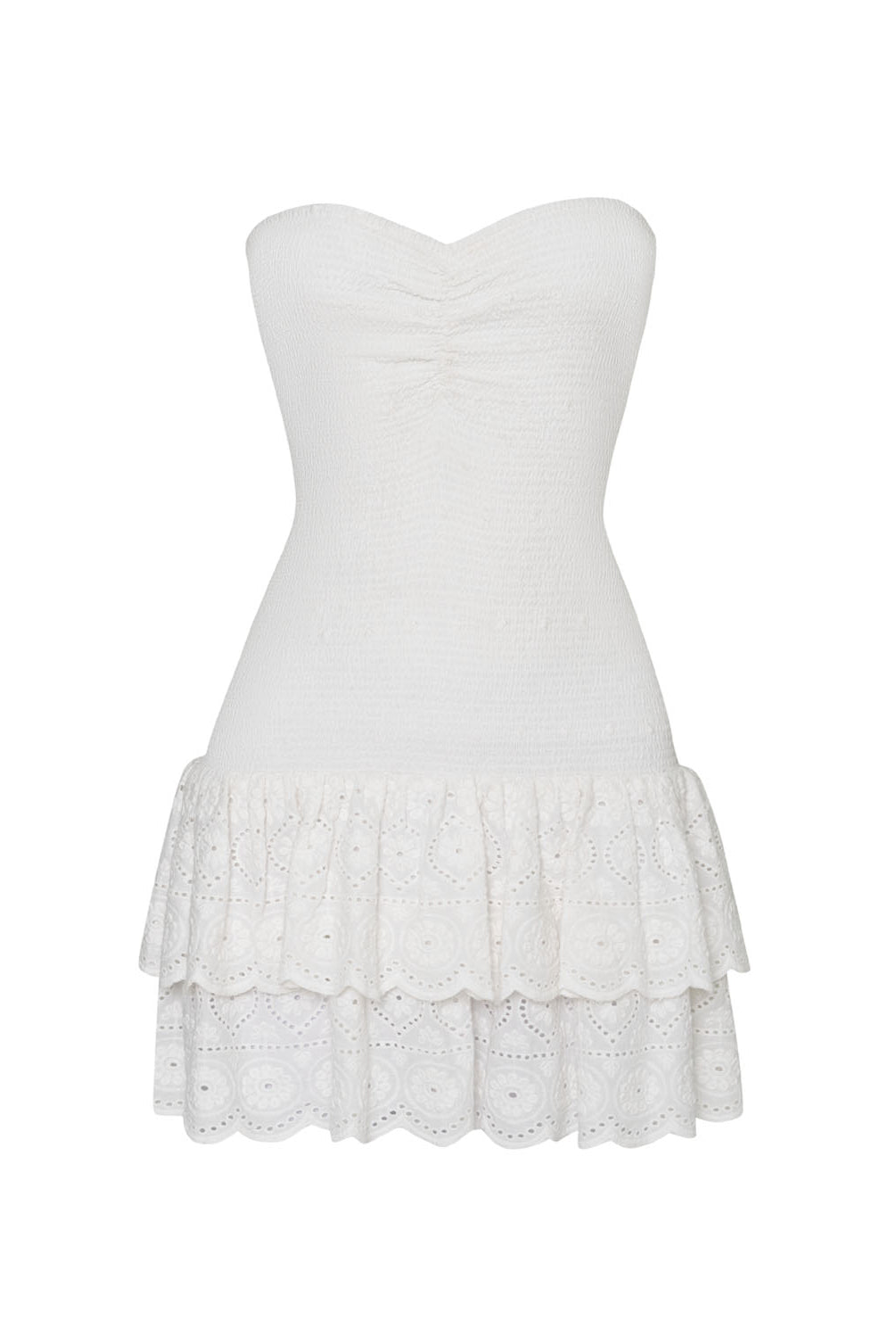 A white mini strapless dress with a ruffle bottom against a white wall.