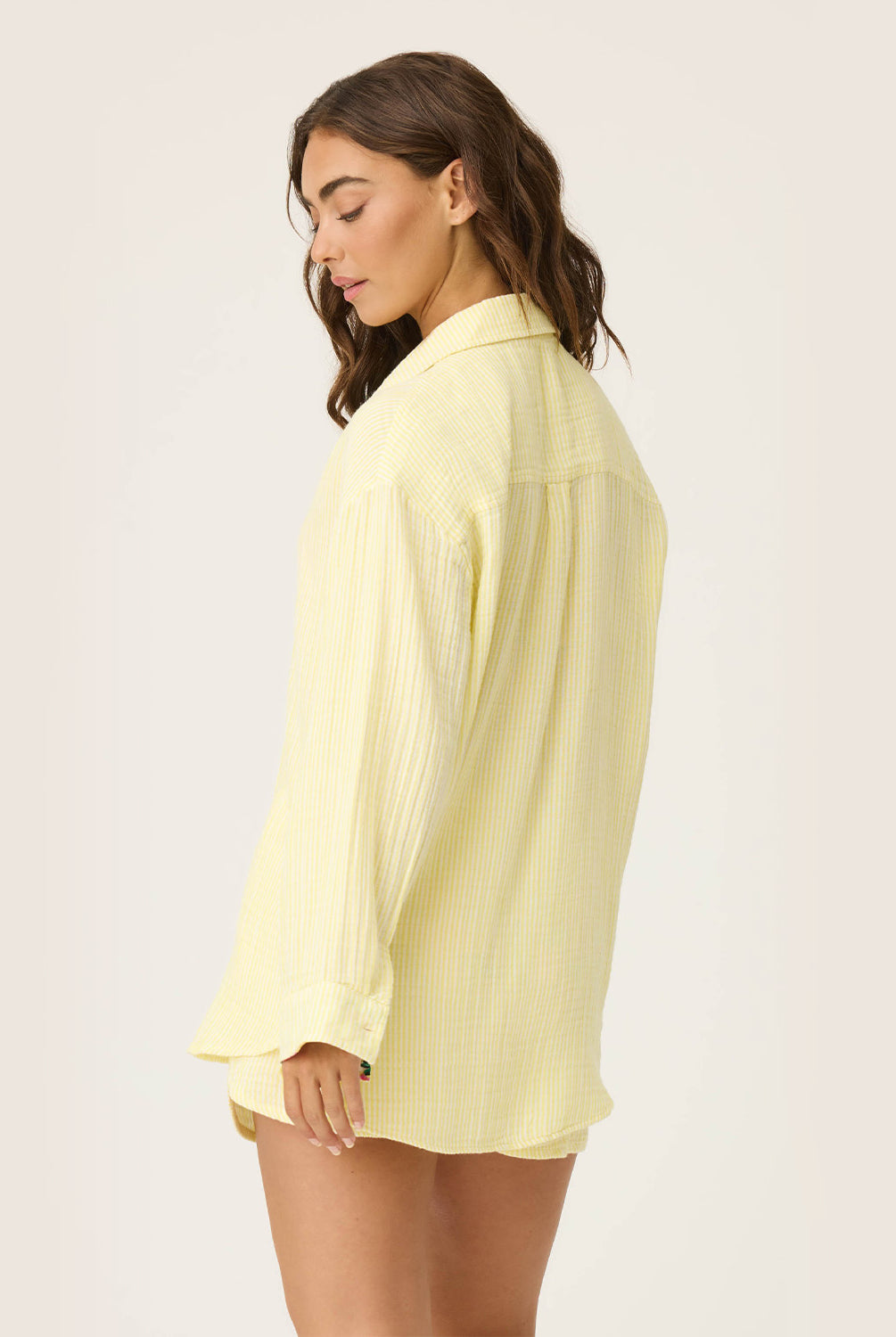 Yellow Gauze Long Sleeve with subtle yellow and white stripes, rolled-up sleeves revealing tropical floral print, button-up front and crisp collar.