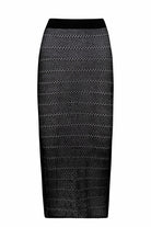 Black, crochet midi skirt in front of a white background.