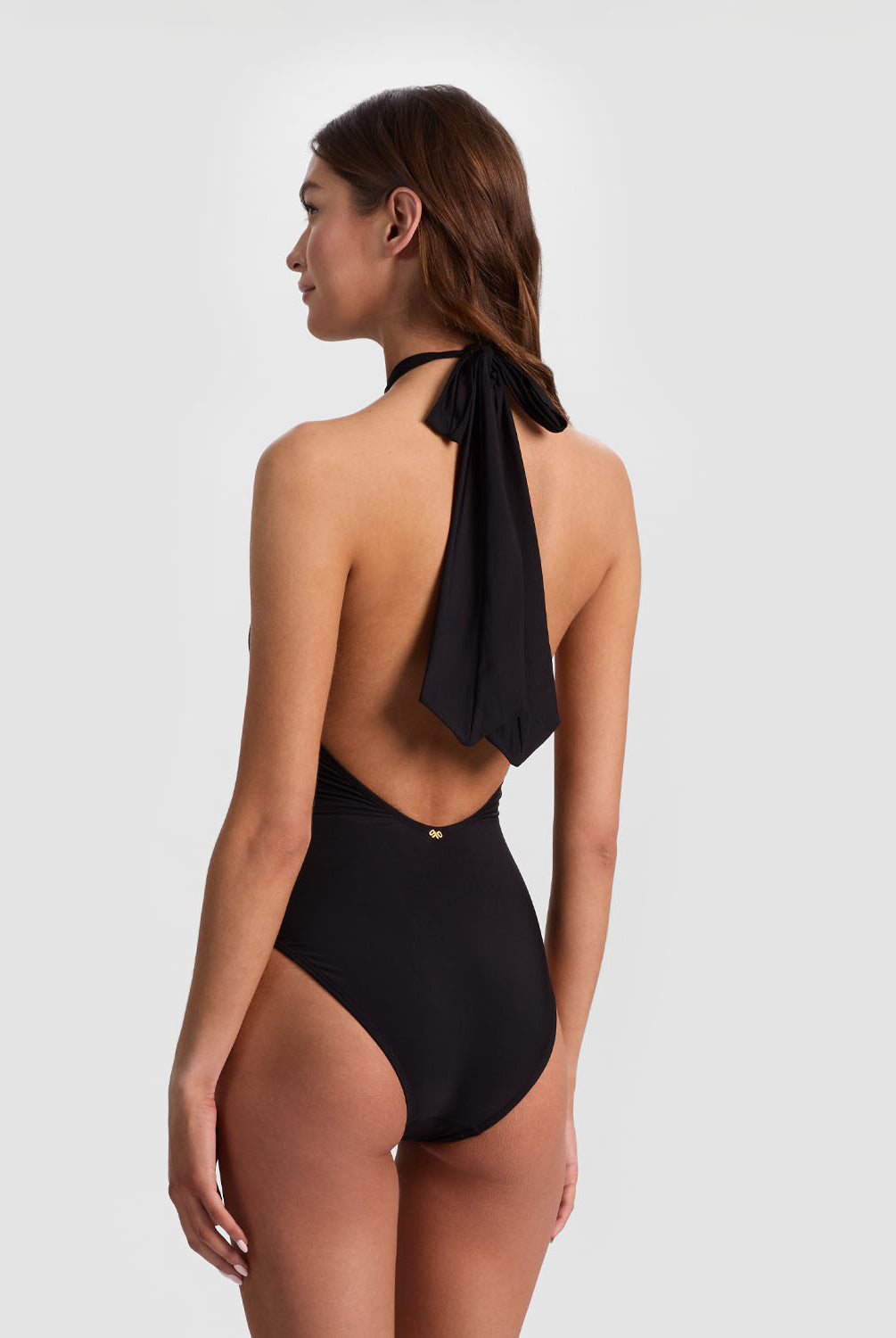 Black Cross Front One Piece from ALICE + OLIVIA x PQ Swim featuring a halter neckline, front peek-a-boo slit, and oversized bow back detail.