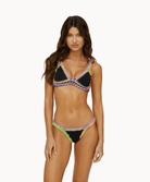 Woman wearing a black crochet bikini in front of a white background.