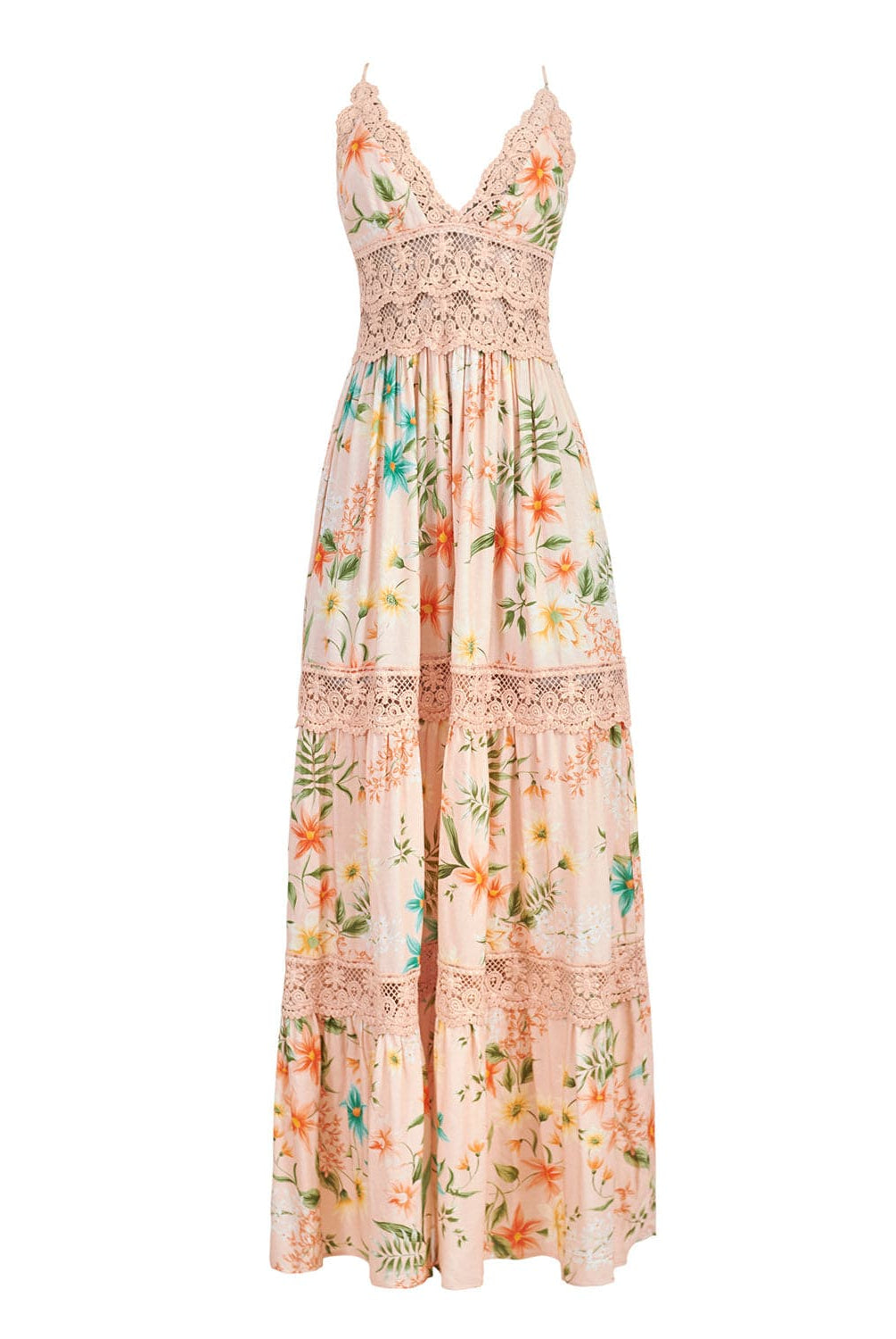 A floor length dress with a tropical print against a white wall. 