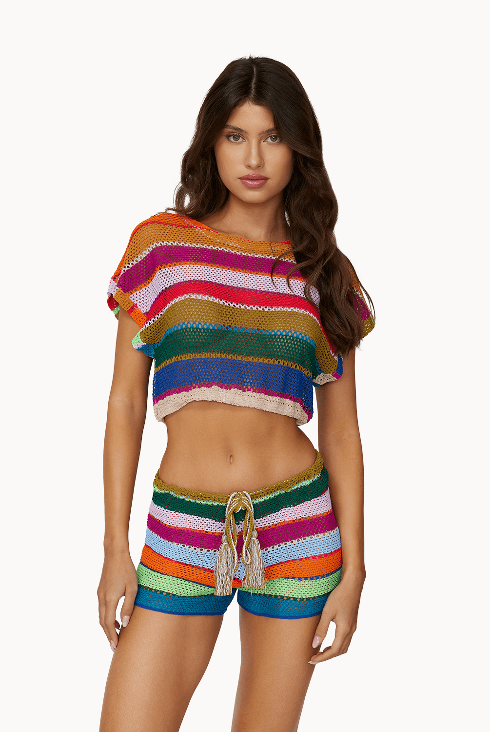 Woman wearing matching colorful, knit top and shorts in front of a white background.