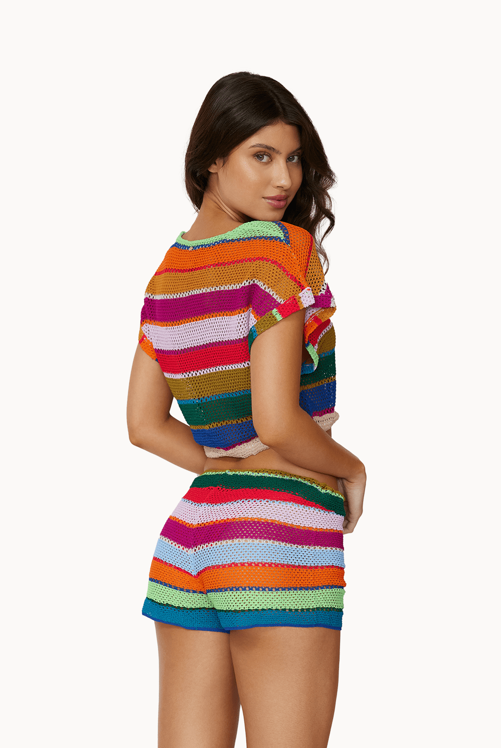 Back view of woman wearing matching colorful, knit top and shorts in front of a white background.