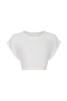 Cream knit crop top in front of a white background.