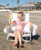 Kids Dahlia Ruffle Bikini – pink floral two-piece swimsuit with bold ruffles and adjustable neck ties.