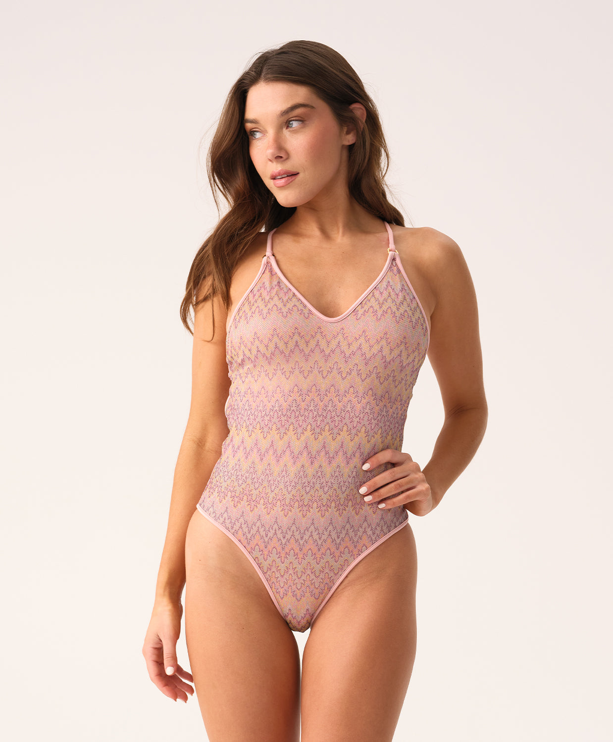Woman wearing a pink patterned swimsuit on a white background