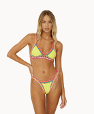 Woman wearing yellow crochet bikini in front of a white background.
