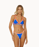 Woman wearing blue crochet bikini in front of a white background.