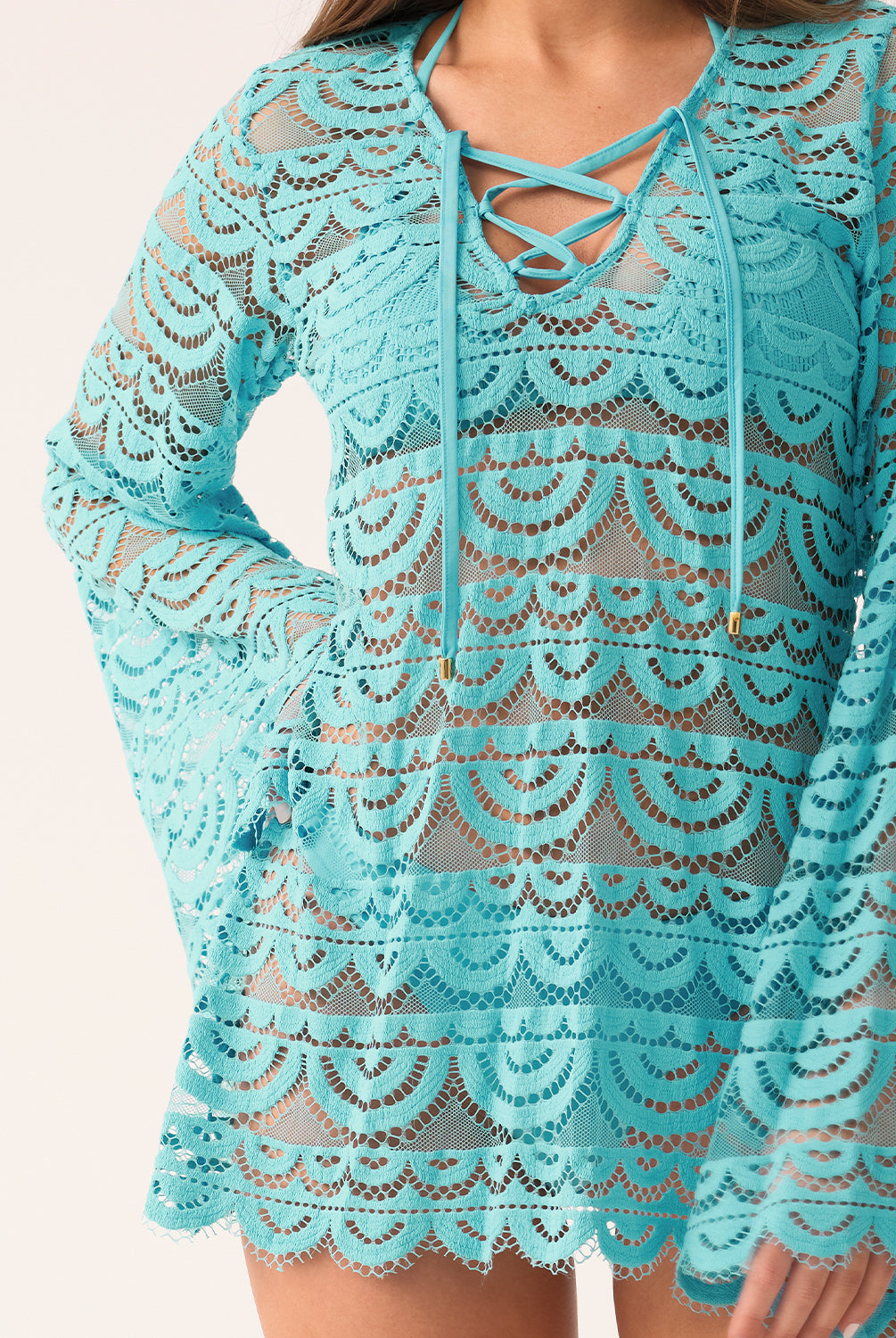 A close-up of a blue lace cover-up with long, bell sleeves and a lace-up v-neck.