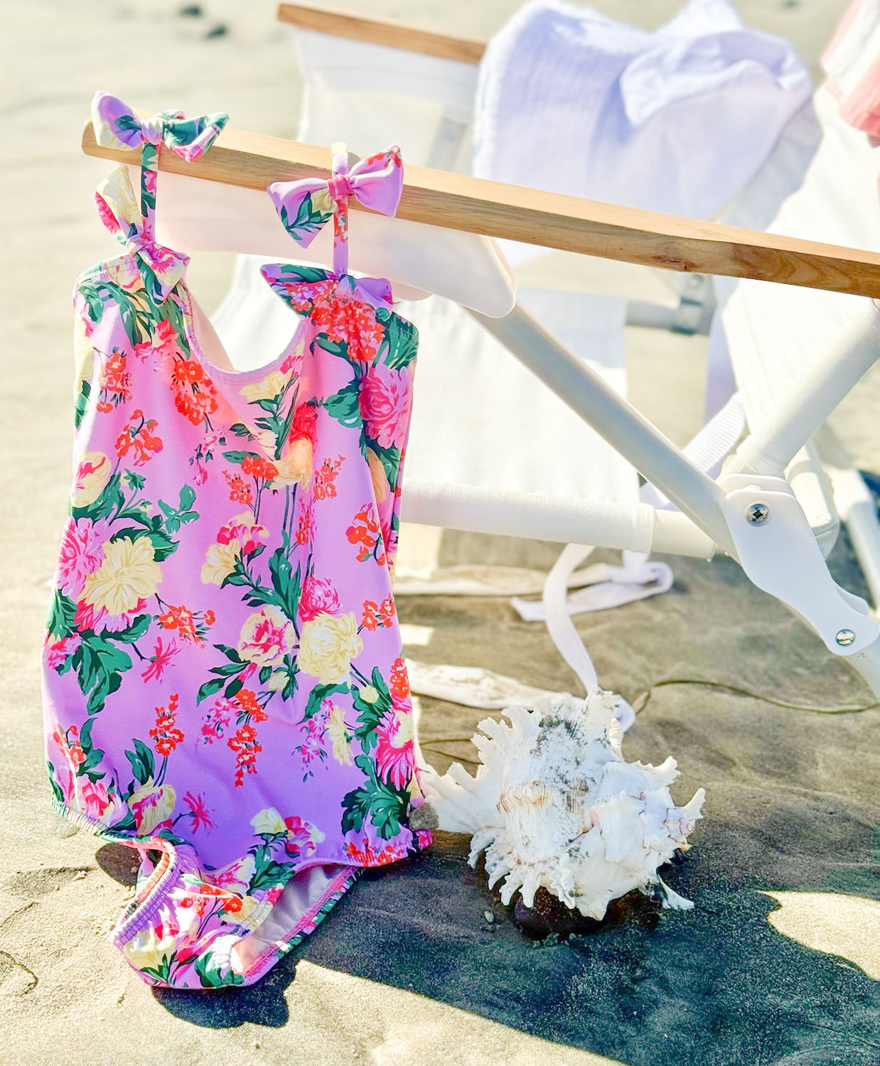 Kids Dahlia Maddie Bow One Piece swimsuit with vibrant pink floral print and bow strap details.