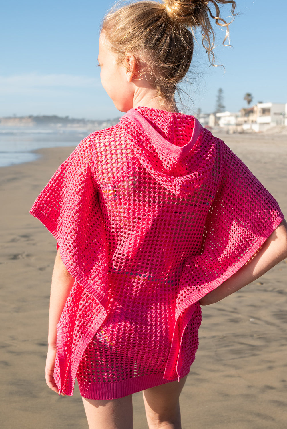 Kids Hot Pink Reagan Poncho with cozy hood and drawstrings, perfect for breezy beach days and post-swim comfort.