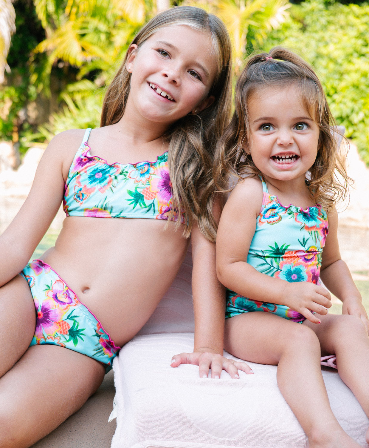 Kids Solana Junie Cut Out One Piece swimsuit with vibrant blue tropical floral print, lettuce-edge trim, and playful cutout details.