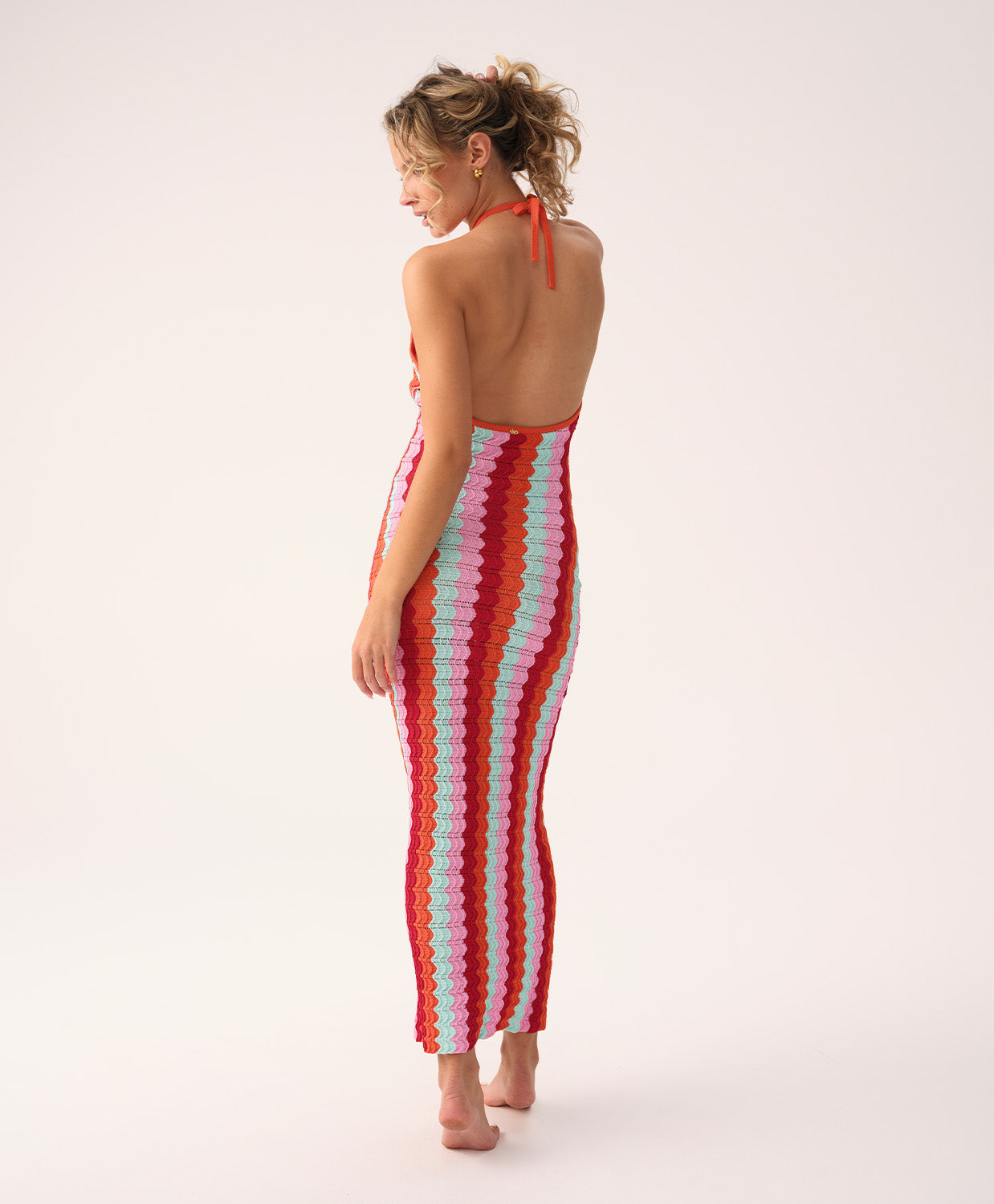 Floor-length multicolor crochet dress with a low back and halter neck ties, called the Milos Aurelia Dress.