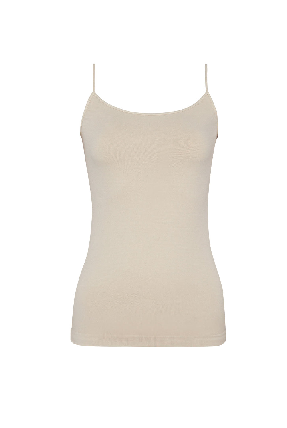 A woman wearing a nude tank top and matching shorts standing against a white wall.