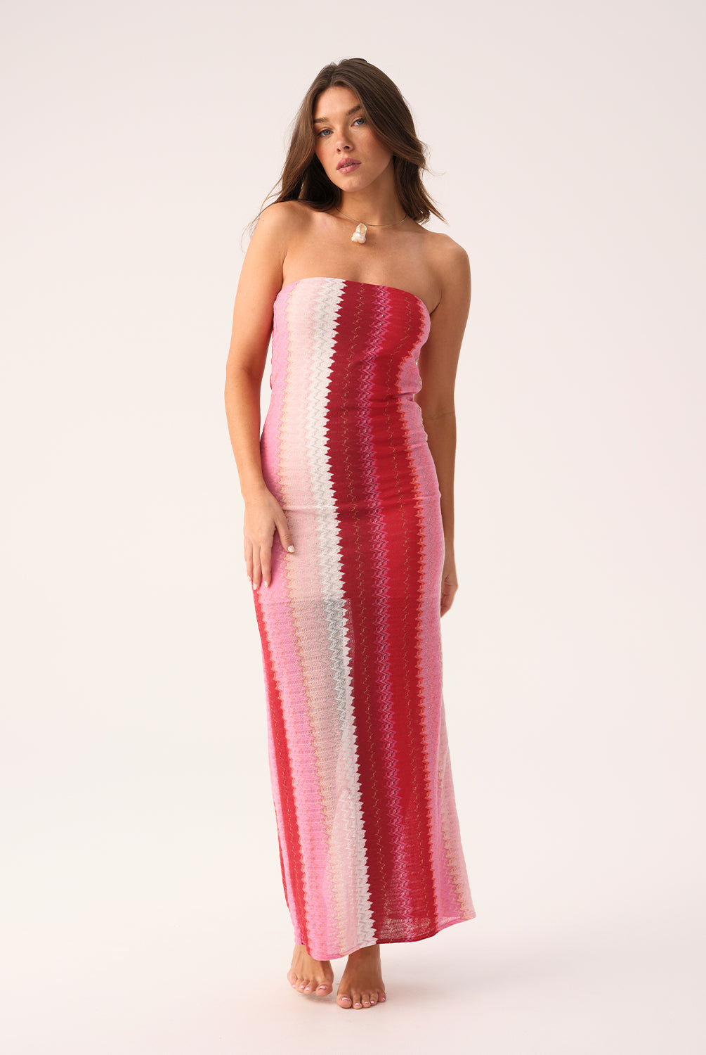 Scarlet Jane strapless dress with vibrant pink, red, and white chevron pattern and gold lurex shimmer, featuring a back slit.