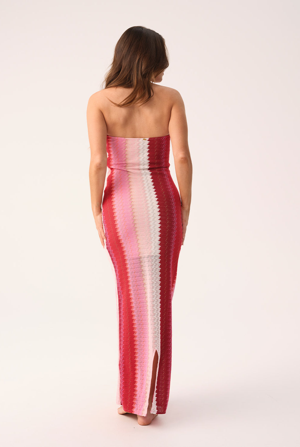 Scarlet Jane strapless dress with vibrant pink, red, and white chevron pattern and gold lurex shimmer, featuring a back slit.