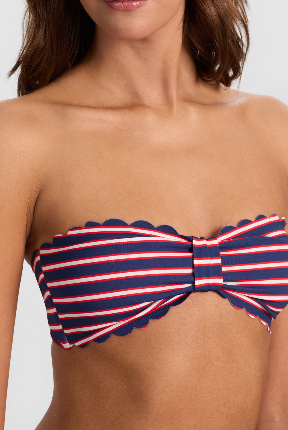 Teakwood Reversible Scalloped Bandeau strapless bikini top with scalloped trim, nautical stripes on one side and sea siren red on the reverse