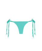 A turquoise bikini bottom against a white wall.