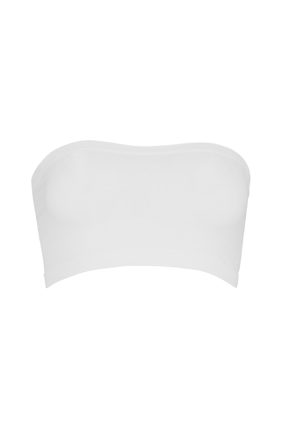 A woman wearing a white bandeau and matching shorts standing against a white wall.