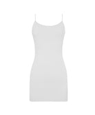 A woman wearing a white mini slip dress standing against a white wall.