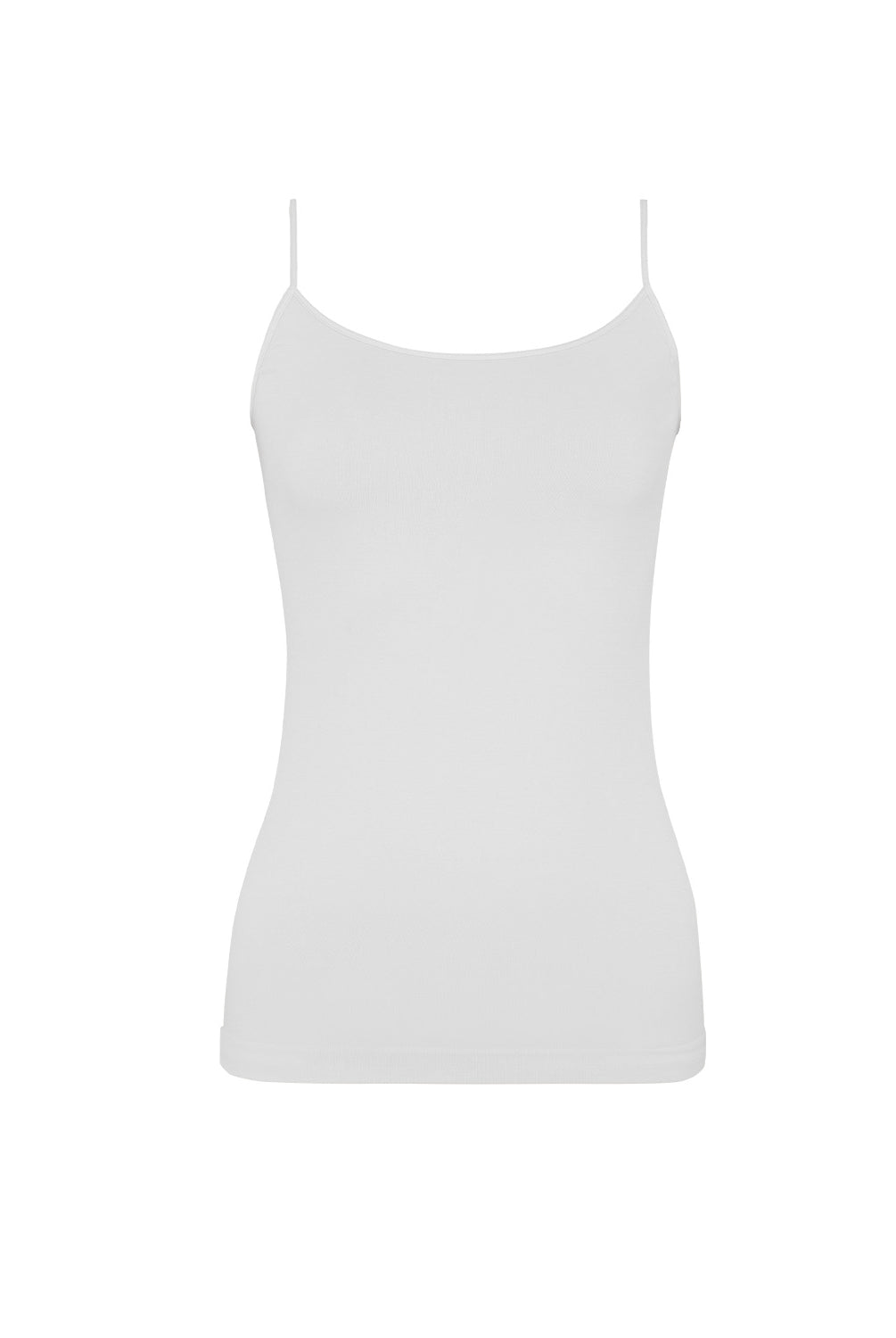 A woman wearing a white tank top and matching shorts standing in front of a white wall.