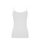 A woman wearing a white tank top and matching shorts standing in front of a white wall.