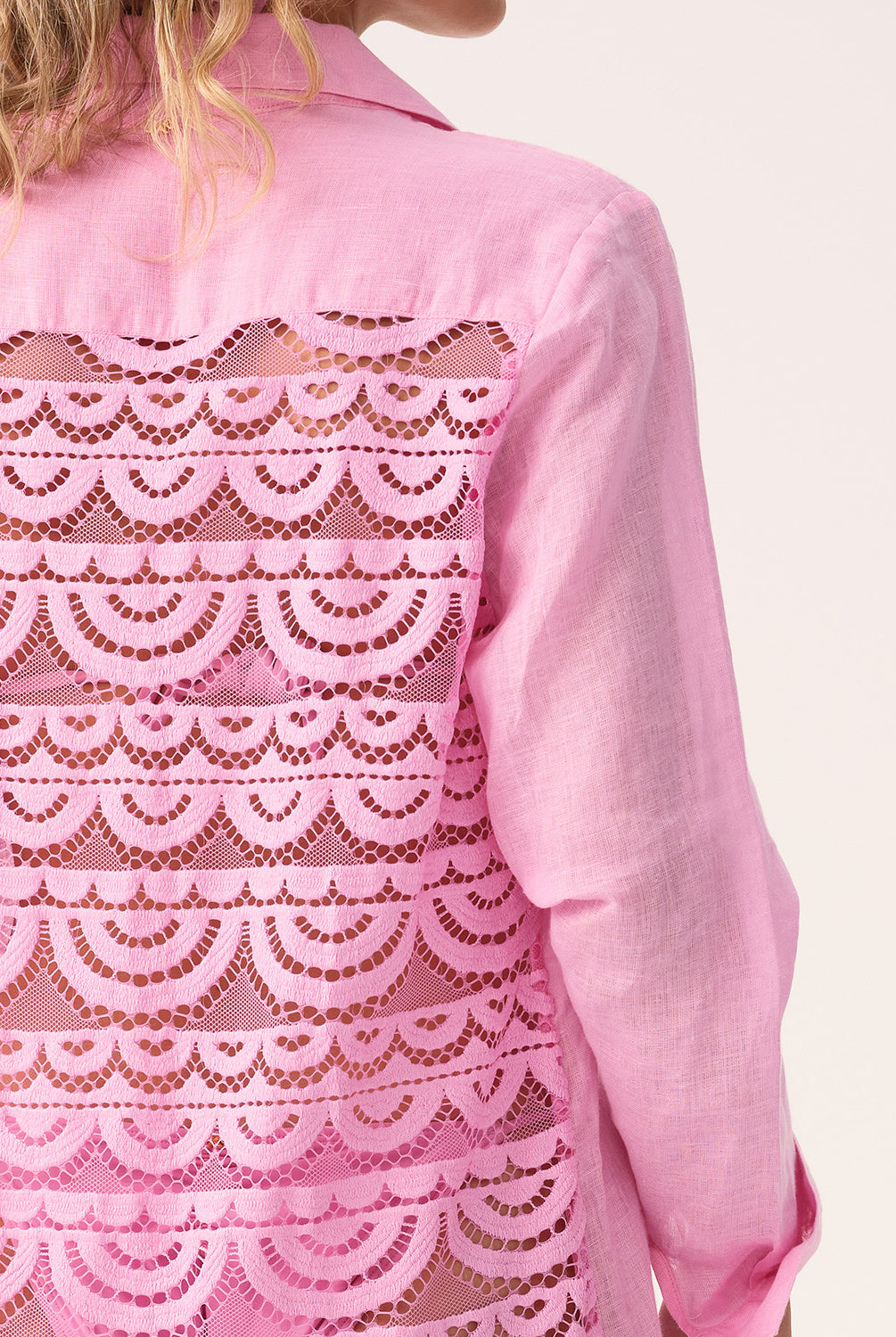 Pink lace-trimmed shirt with scalloped pattern on a white background