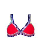 A red bikini top against a white wall.